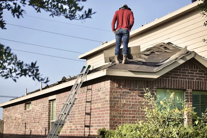 Professional roofer working on a residential roof in Dixonville